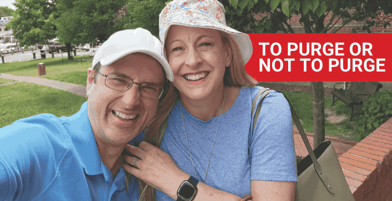 elderly couple side-hugging each other in front of field