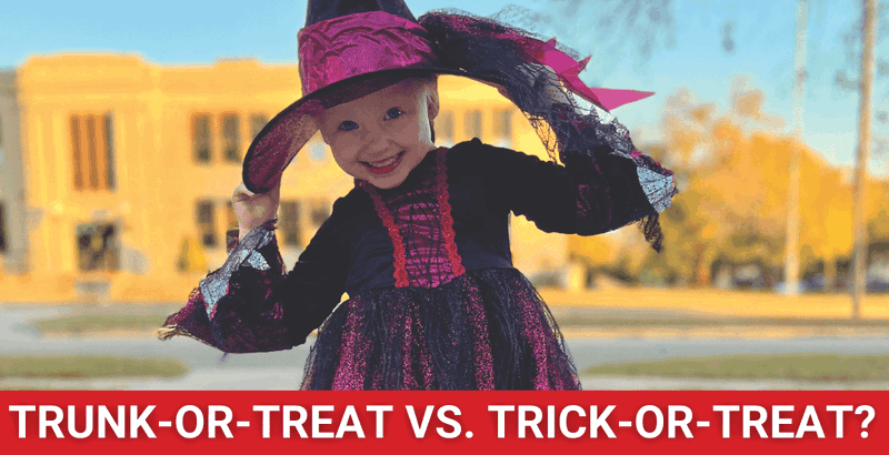 Little girl in black witch costume in neighborhood