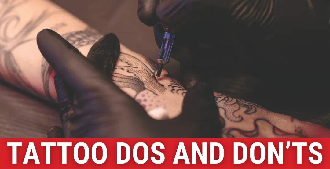 A tattoo artist using their needle to apply ink to person's arm