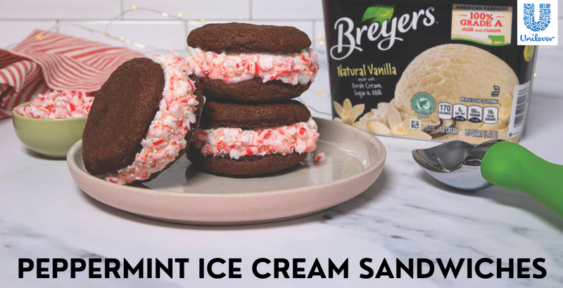 A stack of Peppermint Ice Cream Sandwiches - chocolate cookies with Breyers Natural Vanilla ice cream sandwiched between and then rolled in crushed candy canes